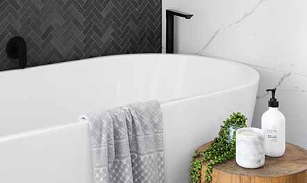White, bright, bathroom remodel with dark grey herringbone backsplash tile and a white marble wall built by Elik.
