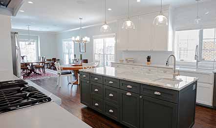 White, bright, open-concept family room interior home remodel with dark grey cabinets and white quartz counters built by Elik.